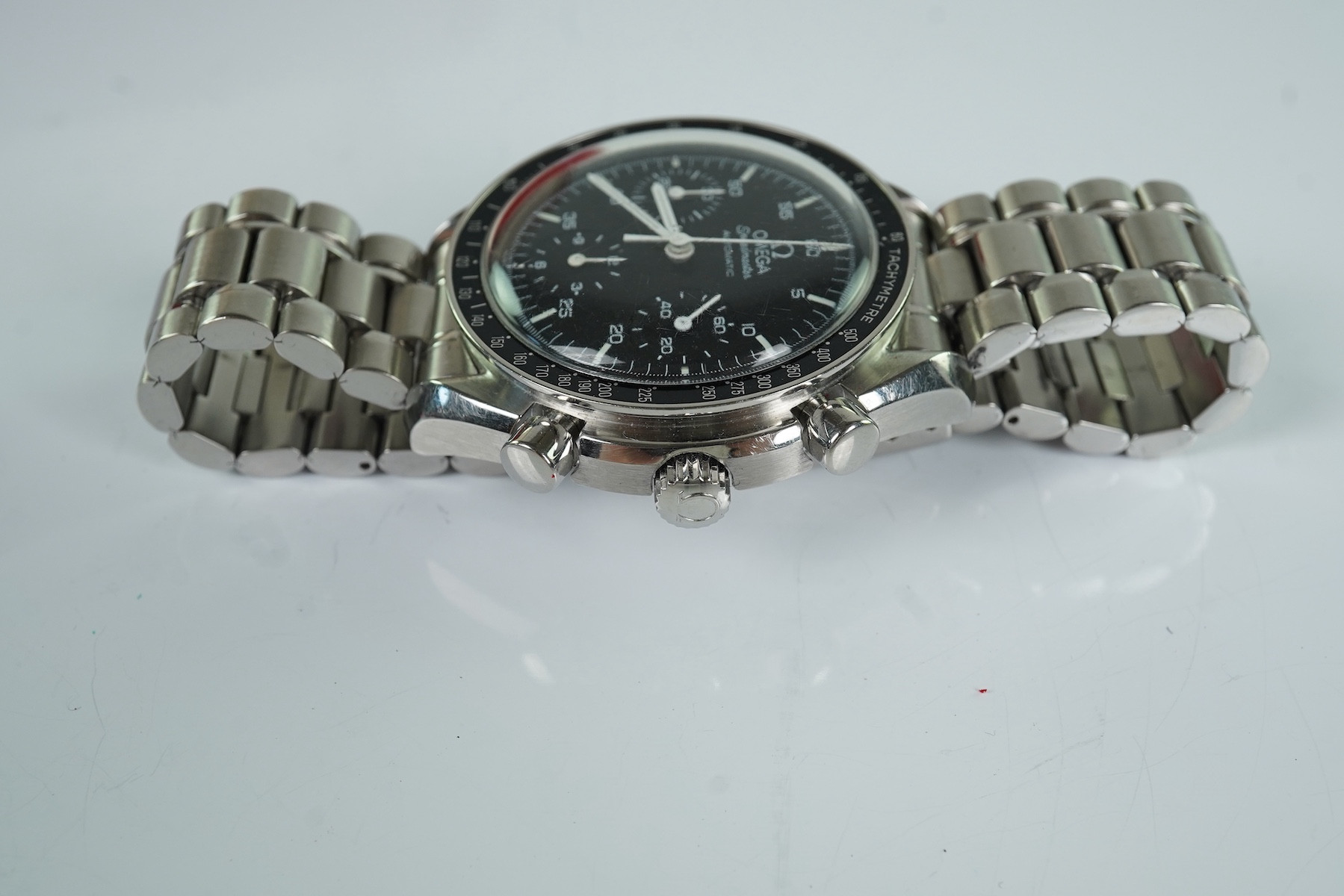 A gentleman's late 1990's stainless steel Omega Speedmaster automatic wrist watch, with box and three pamphlets